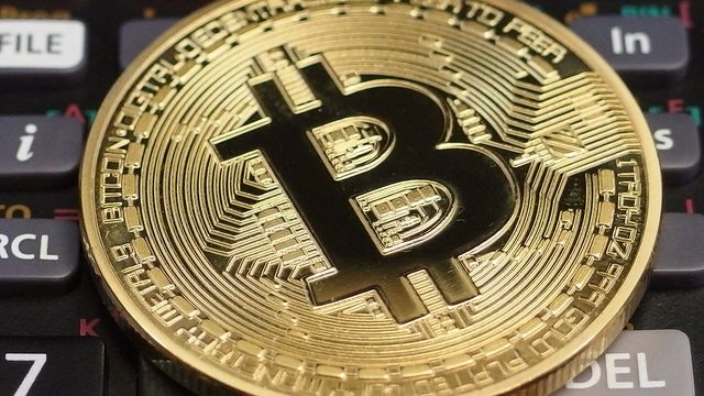 Physical bitcoin coin resting on a calculator keyboard - EarnCrypto Pools five-chain yield APRs