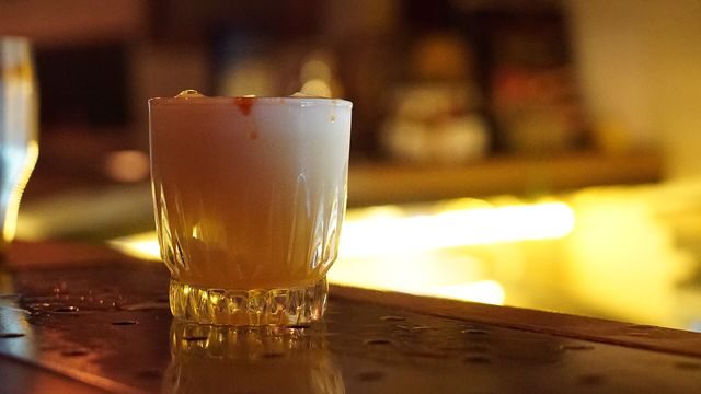 Whiskey cocktail on a polished bar counter in a warmly lit lounge — Single Malt: High Roller's Lounge slot review