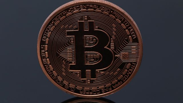 A copper physical bitcoin coin on a dark background — Monero's $600 reclaim and the $615.74 retrace level
