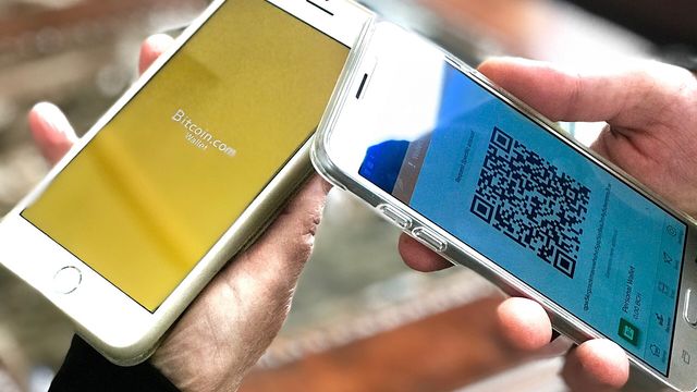 Two mobile phones showing crypto wallet apps being checked — the EarnCrypto Airdrop Checker scanning EVM and Solana wallets for unclaimed airdrop tokens