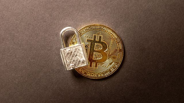 A physical bitcoin coin resting under a transparent padlock on a dark surface - the privacy and security theme behind Zcash's NU7 upgrade to 25-second blocks