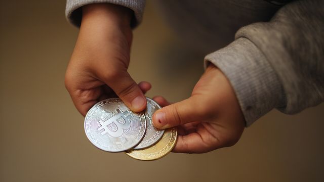 Hands holding physical bitcoin coins — BaseFarmr Base airdrop checker review