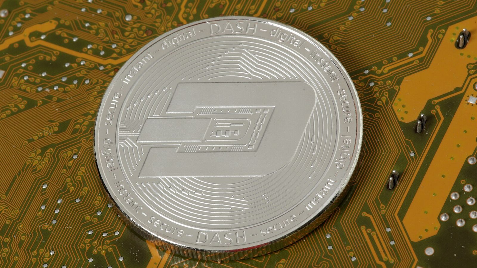Silver physical Dash coin resting on a green circuit board — Dash faucet paying 0.001 DASH every 15 minutes