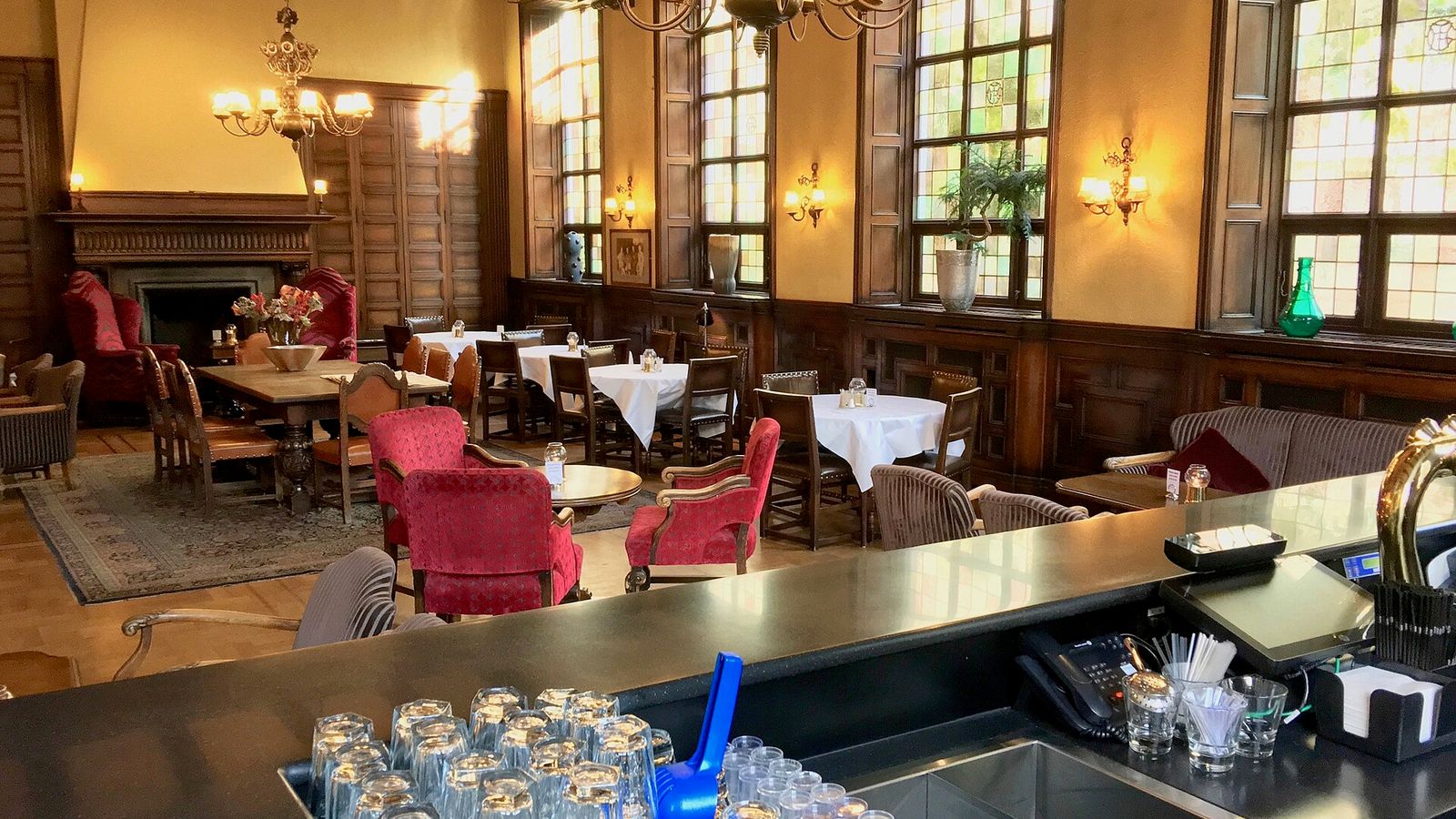 A classic wood-panelled hotel whisky bar with a long counter and rows of glasses — Single Malt: High Roller's Lounge, EarnCrypto's free daily crypto slot