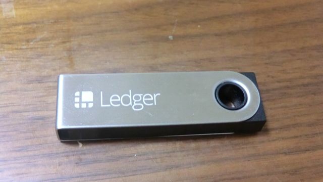 A Ledger Nano S hardware wallet holding cryptocurrency — Polygon's PIP-85 fee split and native staking plan would pay POL stakers from real network fees