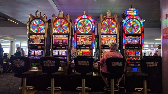 A row of slot machines lit up on a casino floor — Fast & Fortunous, EarnCrypto's free daily street-racing crypto slot