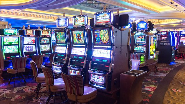 Rows of slot machines on a casino floor — the ten crypto cabinets on the EarnCrypto slots floor