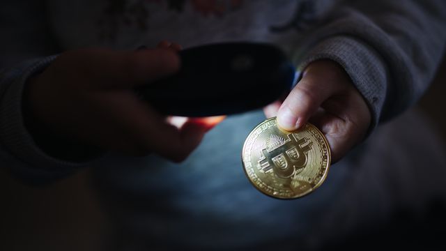Hands holding a physical crypto coin under a phone light — the Solana Faucet pays 0.002 SOL every 15 minutes with instant Phantom withdrawals