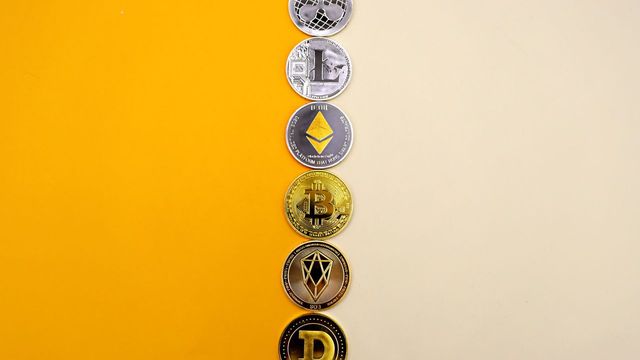 A row of cryptocurrency coins on a yellow surface — resigning abandoned ETH and SOL transactions with Unclaimed Resigner