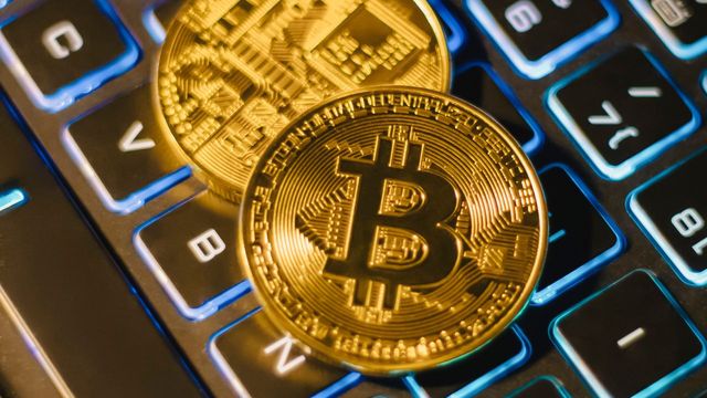 Two bitcoin coins resting on an illuminated keyboard — Ethereum Mining AI's SmartPool neural net across six pools