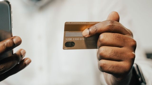 A person paying with a smartphone and card — Injective putting $1B of mortgage records onchain