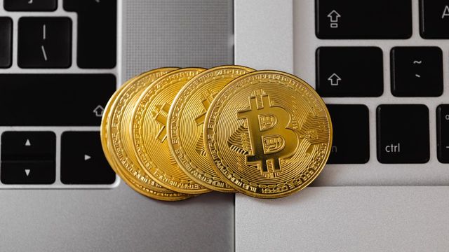 Bitcoin coins resting on two laptop keyboards — how seed phrase scanning brings old bitcoin back to life