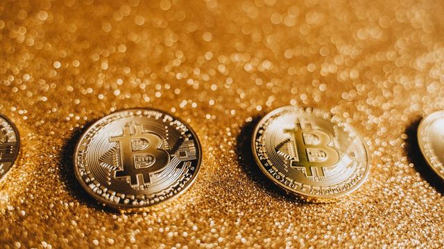 Three bitcoin coins on a sparkling gold surface — Trump pushing the CLARITY Act to the Senate floor with BTC at $71,880