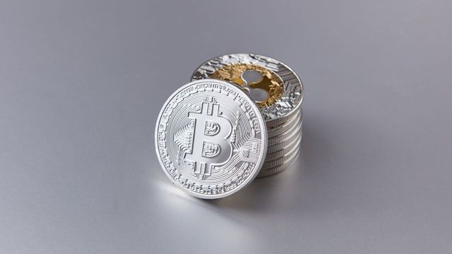 Shiny bitcoin coins with a reflective surface — bitcoin's first golden cross since November 2025