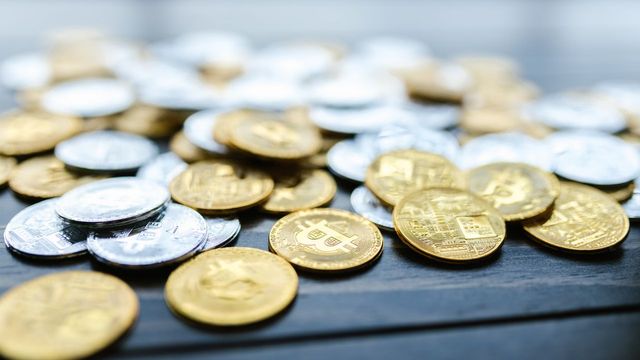 Cryptocurrency coins scattered on a wooden surface — the Multi-AI Sniper bot watching 12 chains for launches