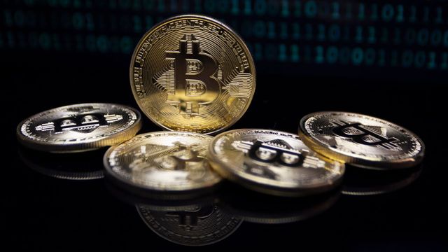 Gold bitcoin coins against a digital binary code background — RewardForge's nine AI reward pools and daily payouts