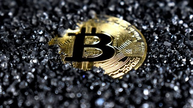 A gold and black crypto coin emblem — Tezos up 50% in a month as Tezos X waits in the Q3 window