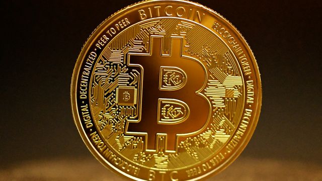 A golden bitcoin coin on a table — bitcoin holding $69,300 after the $1.8B liquidity grab