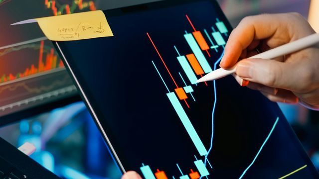 Trader analyzing candlestick charts on tablet and monitor — BCH daily technical analysis